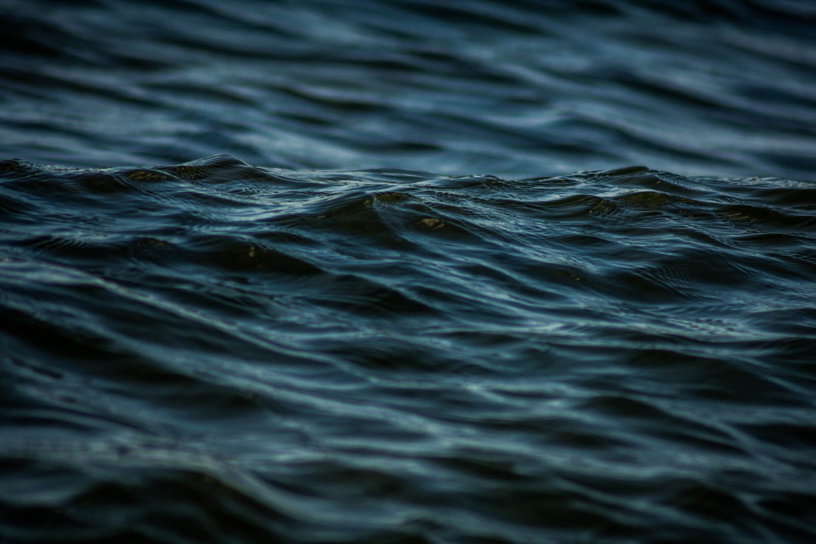 Dunkelblaues, schwarzes Wasser mit Wellen